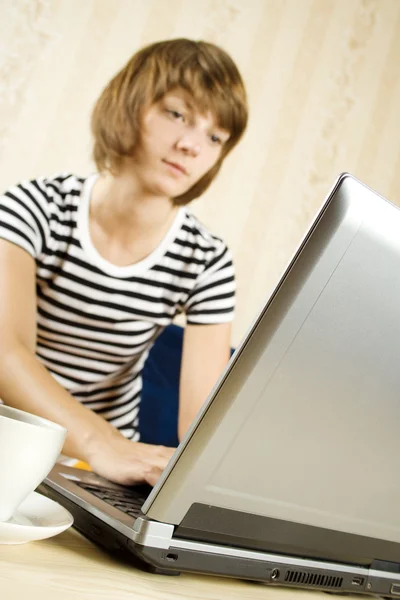 Mujer joven sentada frente a la computadora portátil —  Fotos de Stock