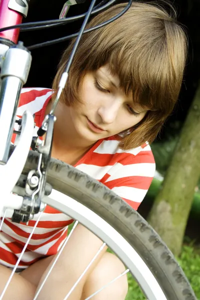 Jong meisje mends fietsen — Stockfoto