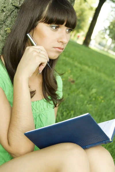 Feminino em um parque com um caderno — Fotografia de Stock