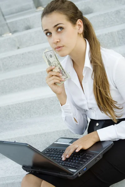 Γυναίκα των επιχειρήσεων με χρήματα και ένα φορητό υπολογιστή — Φωτογραφία Αρχείου