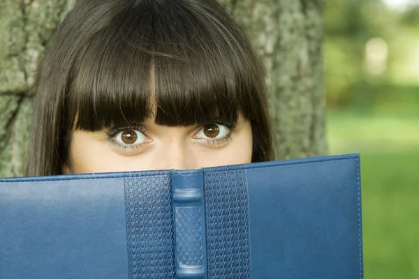 Feminino em um parque com um caderno — Fotografia de Stock