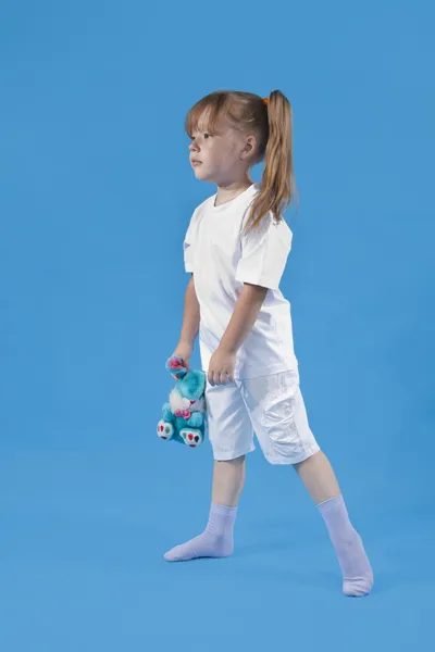 Małe słodkie dziewczyny jest pozowanie na niebieskim tle — Zdjęcie stockowe