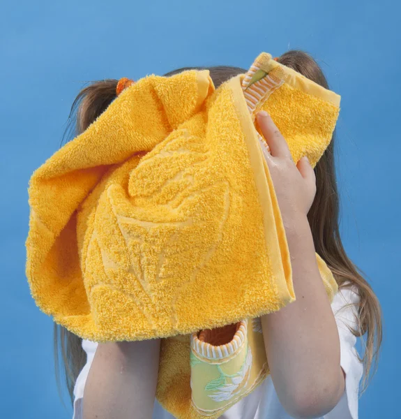 Mała dziewczynka jest wycieranie jego twarz przez ręcznik na białym tle — Zdjęcie stockowe
