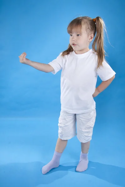 Mała dziewczynka poważne jest pozowanie na białym tle na niebiesko — Zdjęcie stockowe