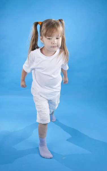 Small serious girl is posing as fighter isolated on blue — Stock Photo, Image