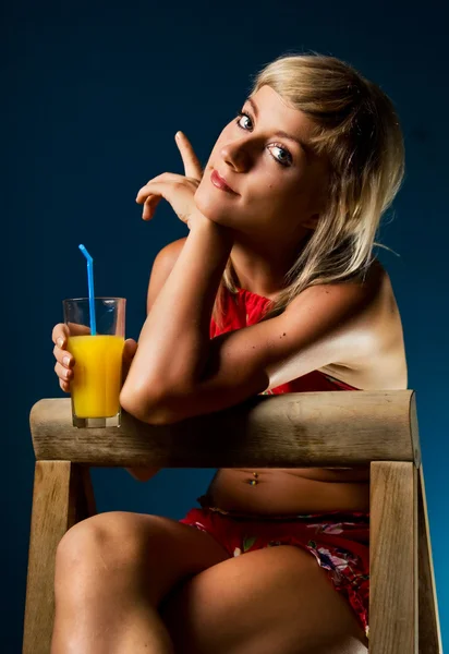 Söt blondin poserar med ett glas saft — Stockfoto