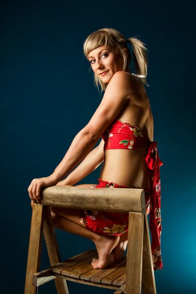 Söt blondin poserar på en stol — Stockfoto