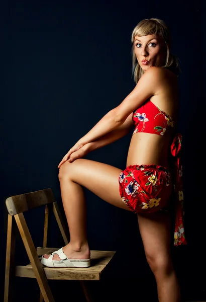 Niedliche Blondine posiert mit einem Holzstuhl — Stockfoto