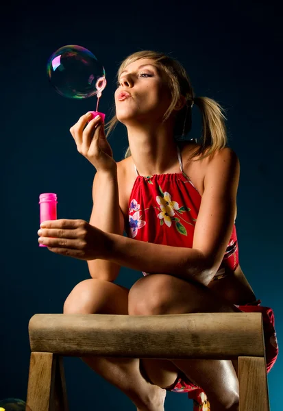 Schattige blonde waait zeepbellen — Stockfoto