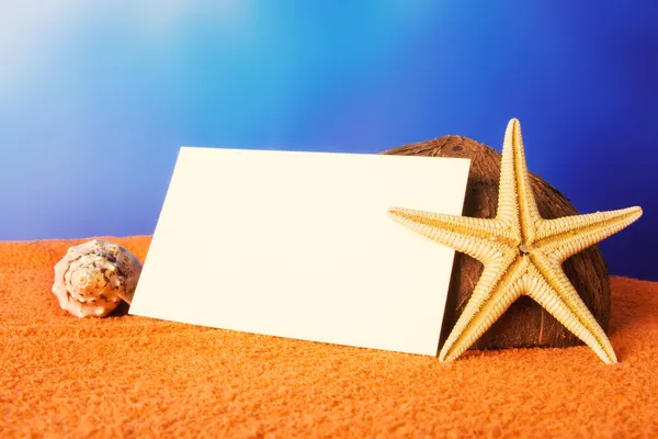Conceito de praia de férias com conchas, estrela do mar e um cartão postal em branco — Fotografia de Stock