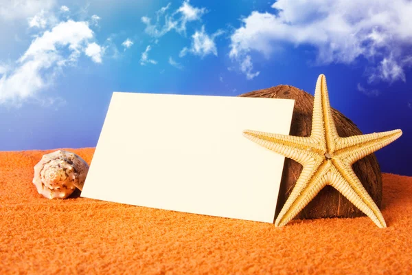 Concepto de playa de vacaciones con conchas, estrella de mar y una postal en blanco —  Fotos de Stock