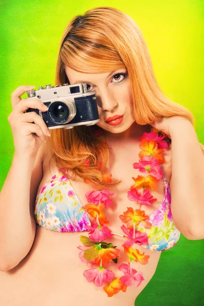 Pinup girl in a bikini holding a vintage camera — 图库照片
