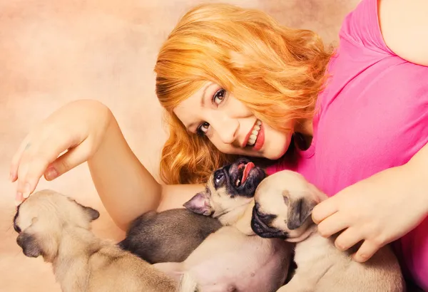 A redhead playing with puppies — Stock Photo, Image