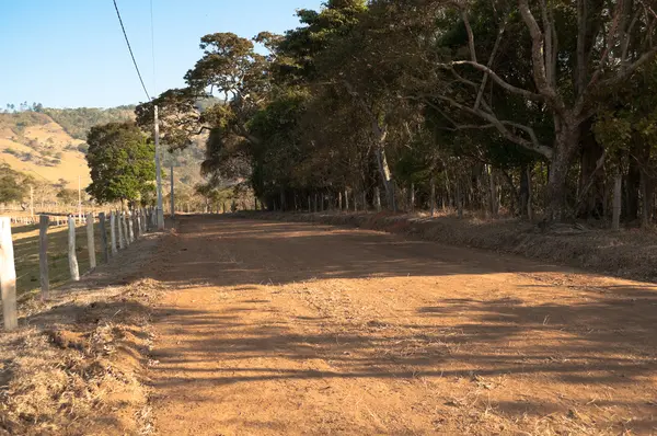 stock image Dirt road on the plain between the farms