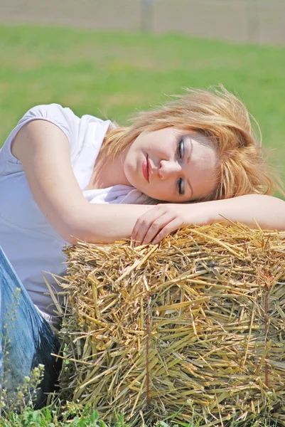 Beautiful girl on a hay bale — Stock Photo, Image