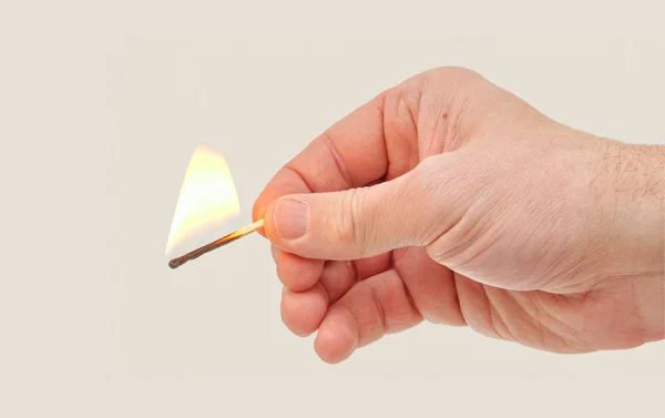 Hand hält ein brennendes Streichholz — Stockfoto