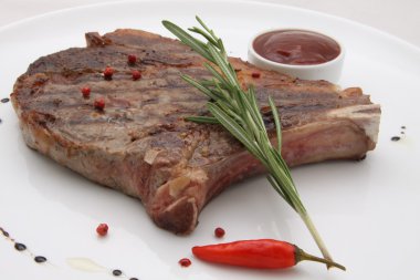 Rib-eye steak resting on a white plate clipart