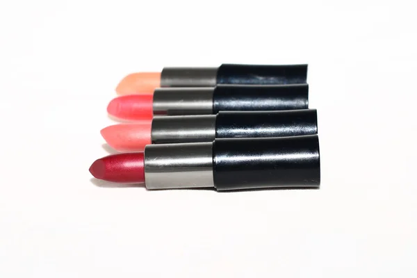 Cuatro barras de labios en un tubo negro —  Fotos de Stock