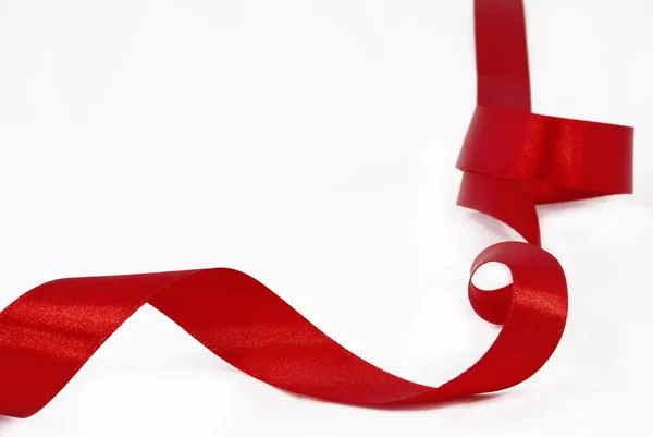 Red satin ribbon on a white background. — Stock Photo, Image