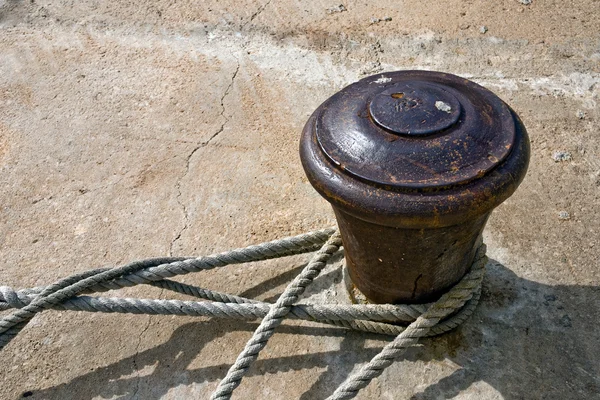 Old rusty bollard with ropes — Stock Photo, Image