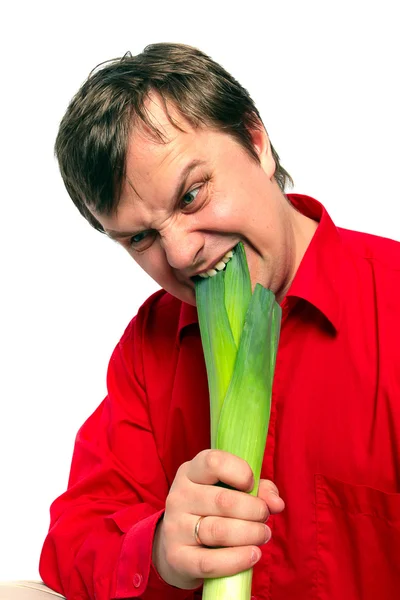 Schöner Mann beißt in einen grünen Lauch — Stockfoto