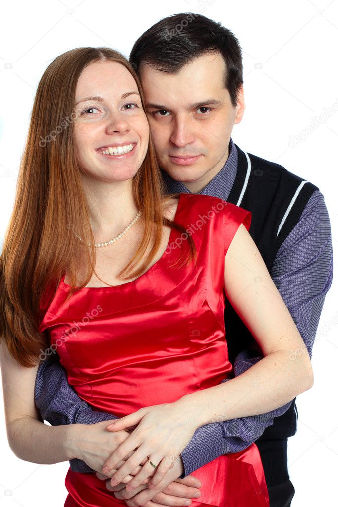 Young man embraces beautiful woman in red.