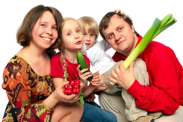 Jovem família alegre com legumes — Fotografia de Stock