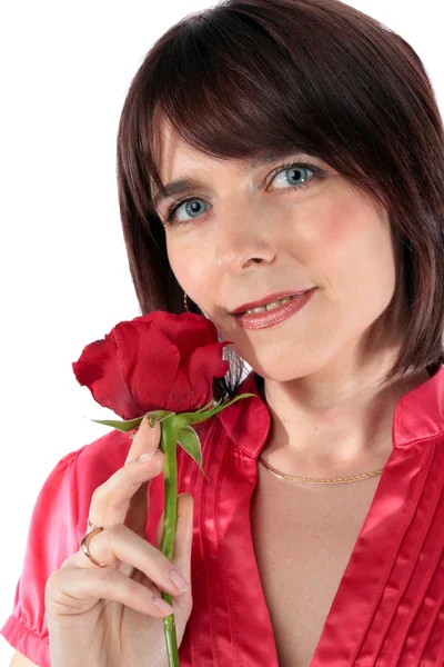 Vacker kvinna som håller en röd ros — Stockfoto