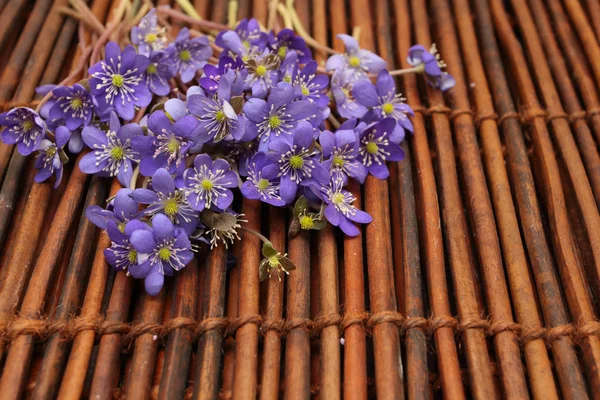 Violette Blüten auf einer braunen Matte — Stockfoto