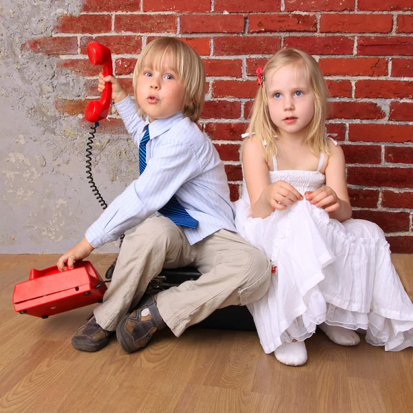 Relationship. Beautiful girl and a boy with a red phone — Stock Photo, Image