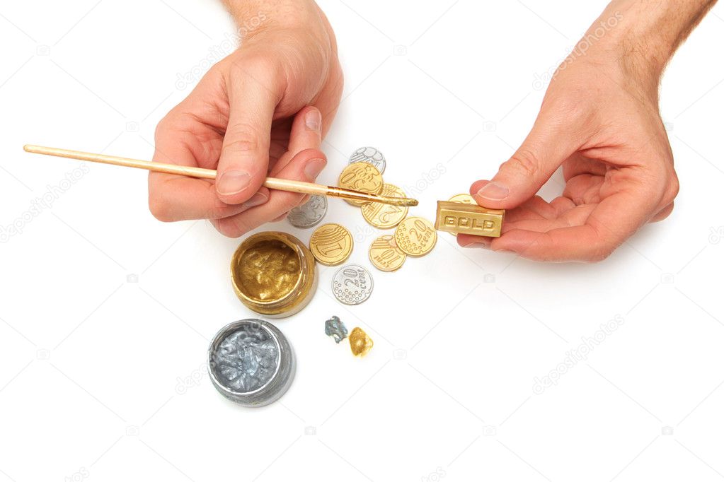 Bullion. Men's hands, gold and silver coins, brush, paint cans