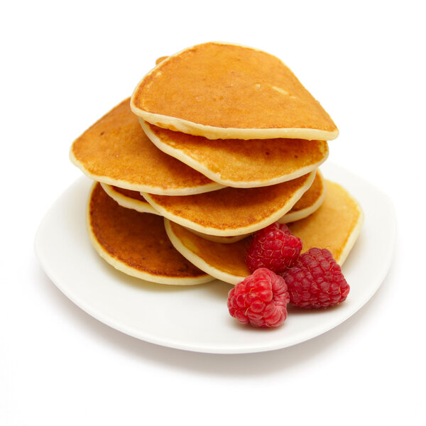 Small pancakes topped with berries isolated on white