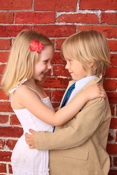 Un niño pequeño abrazando a una chica bonita. Concepto de amor. Contexto —  Fotos de Stock
