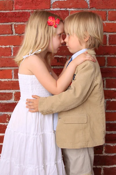 Красивая маленькая девочка и мальчик обнимаются — стоковое фото