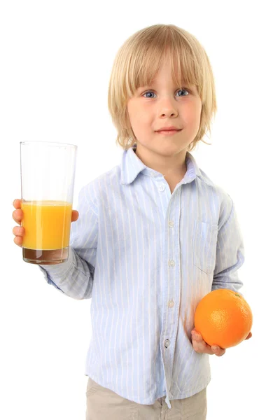 Menino loiro segurando laranja e copo de suco — Fotografia de Stock