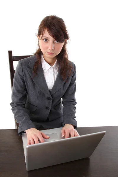 Mladá žena, pracující na notebooku izolovaných na bílém pozadí — Stock fotografie