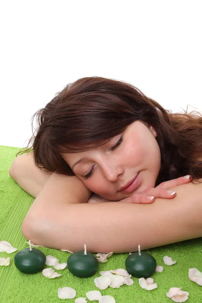 年轻漂亮的女人放松水疗中心绿色毛巾上。呦 — 图库照片