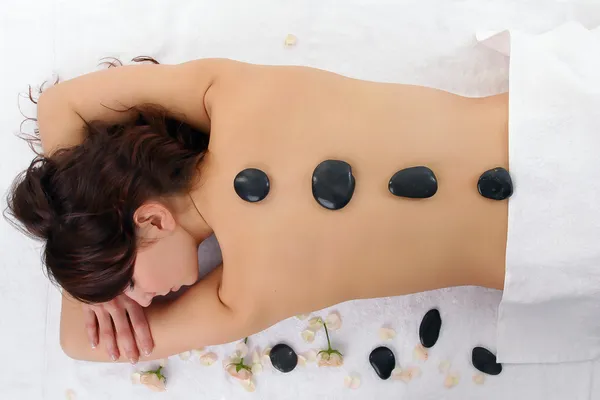 Frau bekommt Wellness-Behandlung isoliert auf weiß. Massage mit heißen — Stockfoto