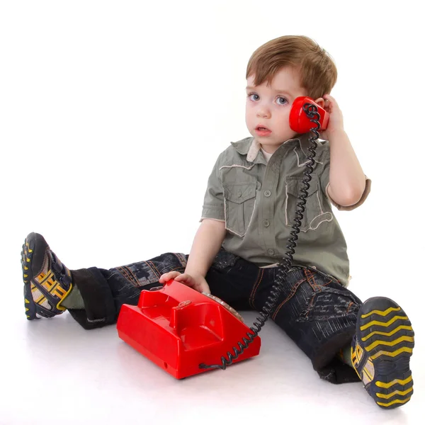 Criança com telefone vermelho isolado no fundo branco — Fotografia de Stock