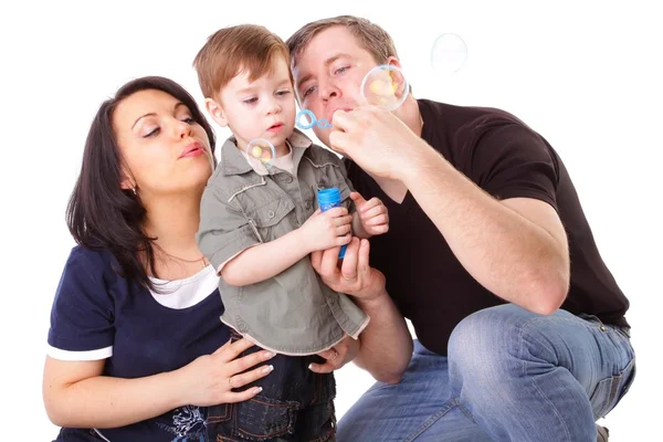 Happy family having fun. Man, woman and child blow bubbles. Seri — Stock Photo, Image