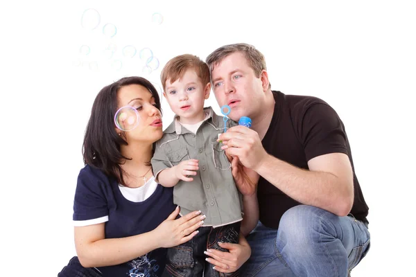 Feliz familia divirtiéndose. Padre, madre e hijo soplan burbujas . —  Fotos de Stock