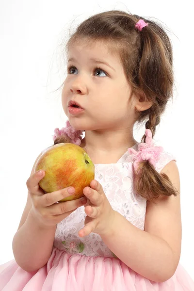Pikkutyttö, jolla on saparot syömässä kypsää omenaa — kuvapankkivalokuva