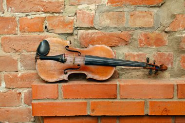 Old violin and empty red brick wall clipart