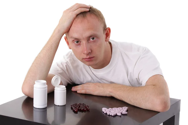 Uomo e pillole isolato su bianco — Foto Stock