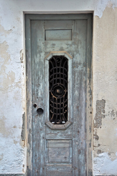 Weathered derelict house wooden door. Vintage metalwork pattern.
