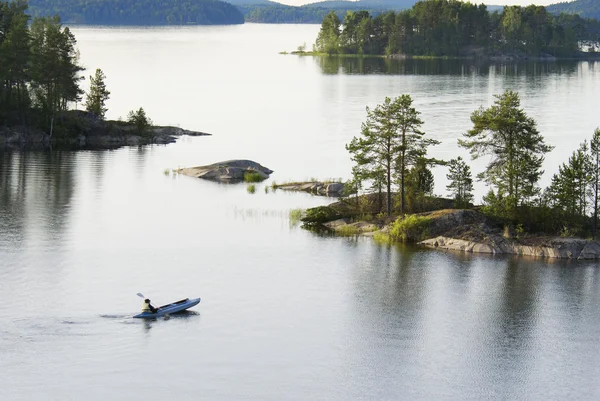 Personen som flyter med en båt på sjön — Stockfoto