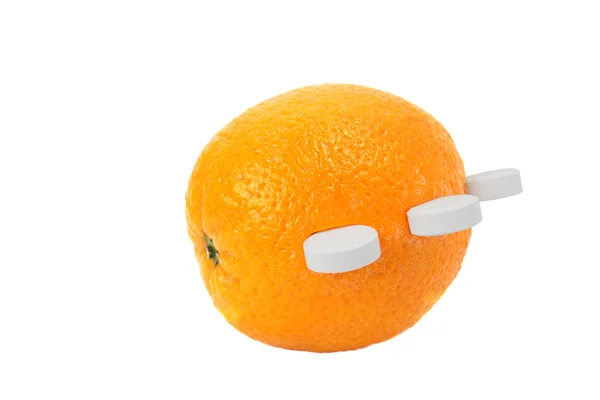 Oranje met pillen van vitamine c op wit — Stockfoto
