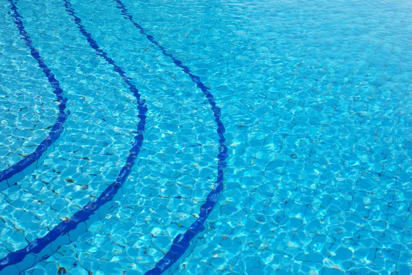 Blauwe achtergrond met zon weerspiegeld in het zwembad water — Stockfoto