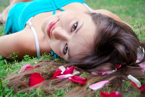 Meisje en bloemblaadjes van roos — Stockfoto