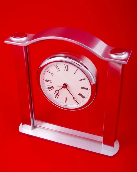Relógio sobre um fundo vermelho — Fotografia de Stock